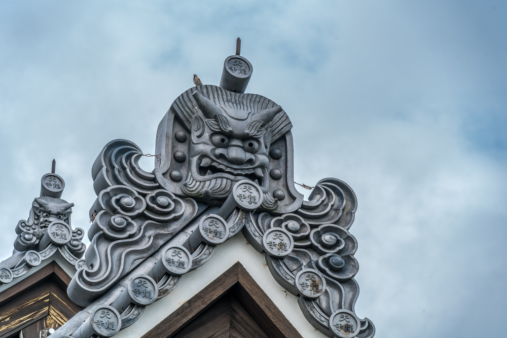 ตำนานของญี่ปุ่น Onigawara (goblin Ogre tile) roof detail, "Tenryuji Temple" Inscription in circular tile (marugawara). Tenryu-ji Temple Complex, Kyoto